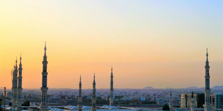Stunning view of the Prophet's Mosque minarets at sunset in Medina, Saudi Arabia.