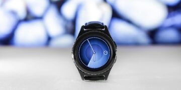 A sleek digital smartwatch with a blue interface against an abstract blurred background. Stylish and modern.