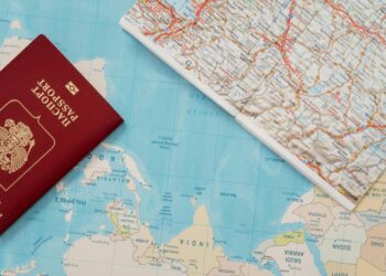 Flat lay of a passport and map, symbolizing travel adventure and exploration.