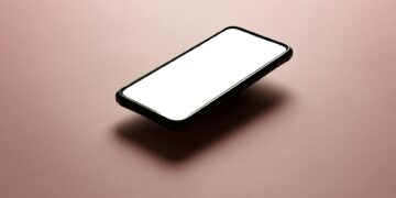 A smartphone with a blank white screen on a pink background, perfect for mockups.