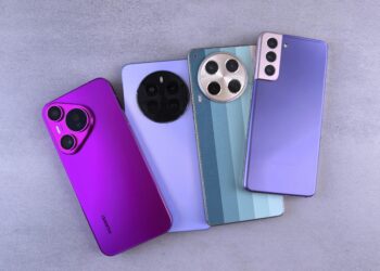 Array of colorful modern smartphones displayed on a grey surface.